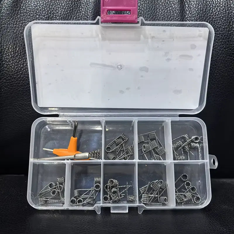 Beast Master 10 in 1 Coil Kit. Clear plastic box with compartments containing vape coils on a dark textured surface.