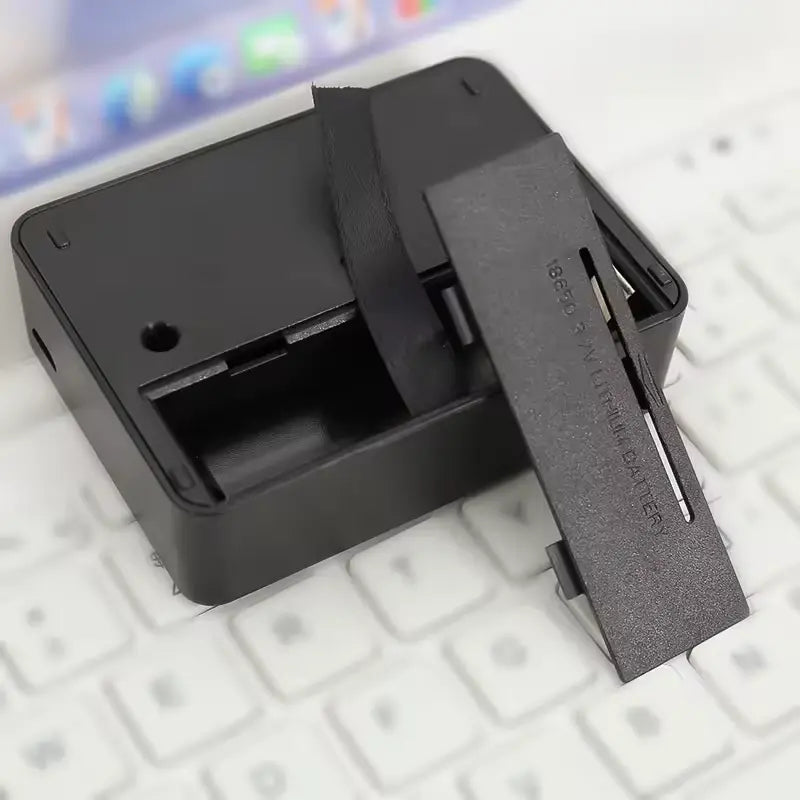 Black electronic device with a sliding cover on a keyboard background