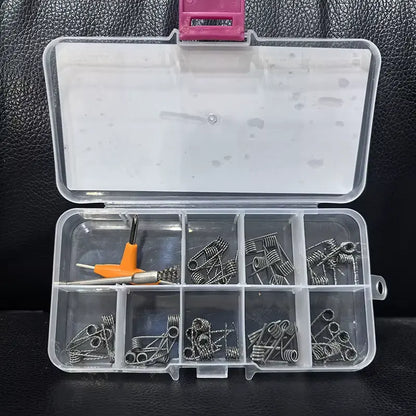 Beast Master 10 in 1 Coil Kit. Clear plastic box with compartments containing vape coils on a dark textured surface.